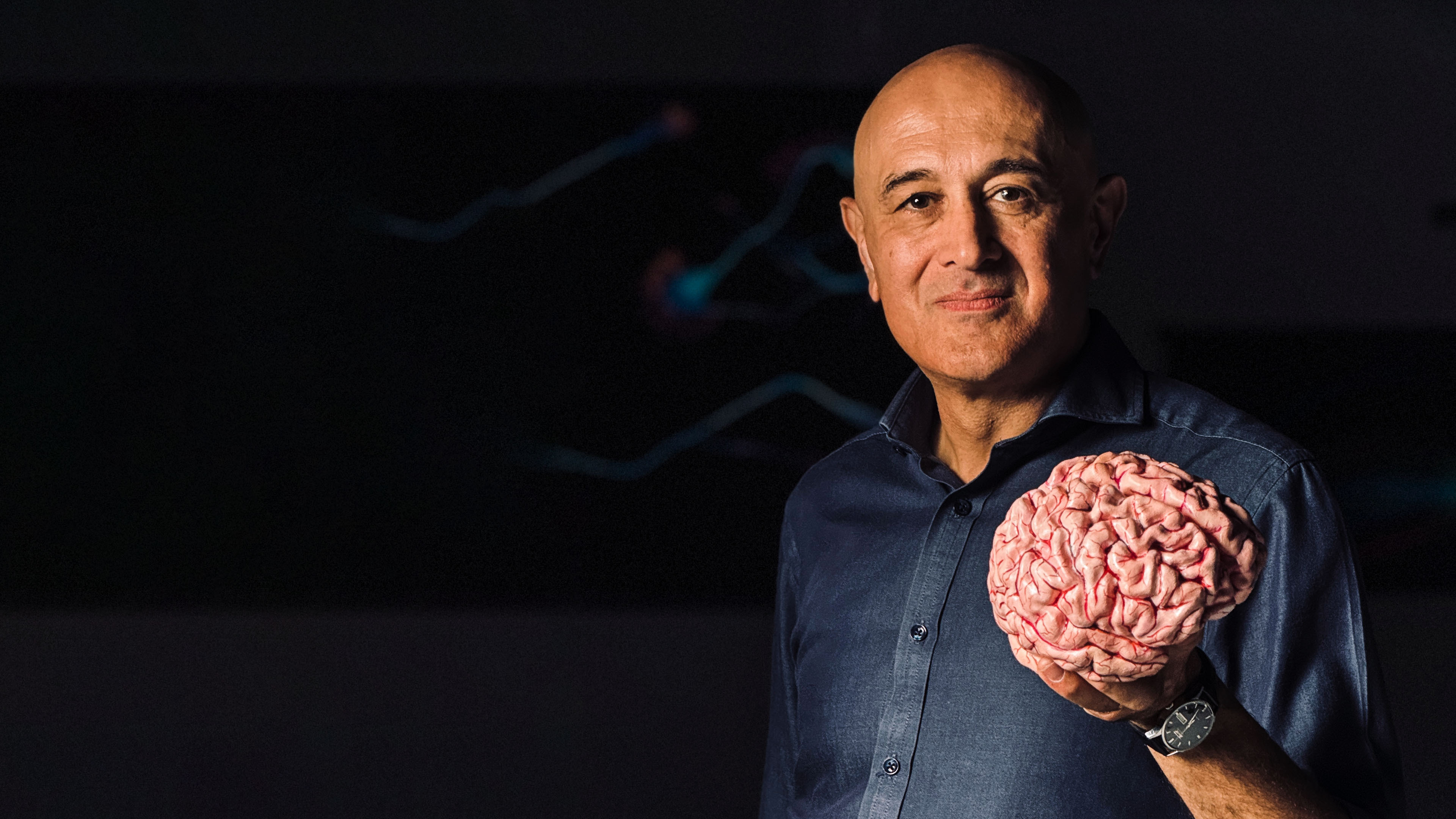 Professor Jim Al-Khalili holding a 3D printed brain in his left hand.
